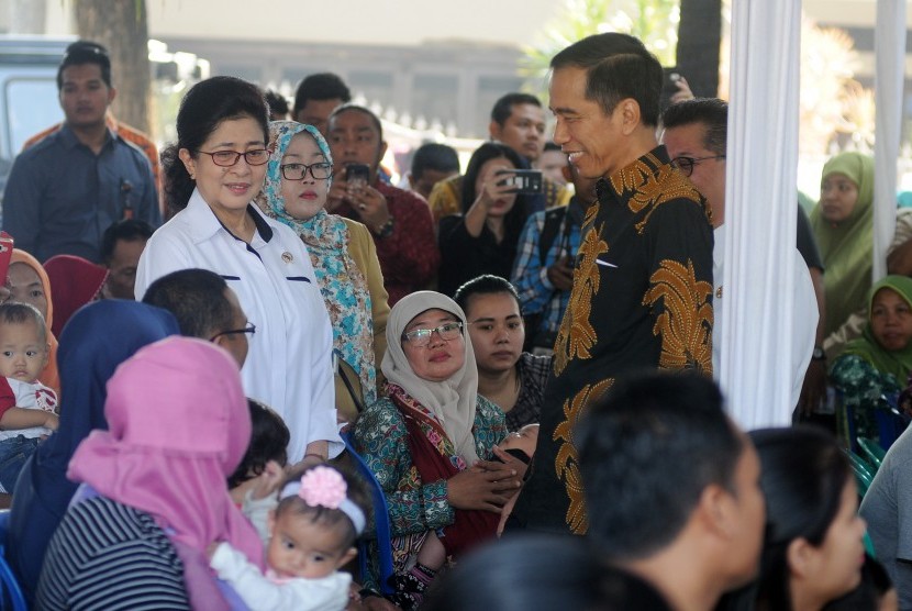 Presiden Joko Widodo (kanan) didampingi Menteri Kesehatan Nila F Moeloek (kiri) berbincang dengan orangtua korban vaksin palsu saat meninjau pelaksanaan vaksinasi ulang di Puskesmas Kecamatan Ciracas, Jakarta Timur, Senin (18/7).