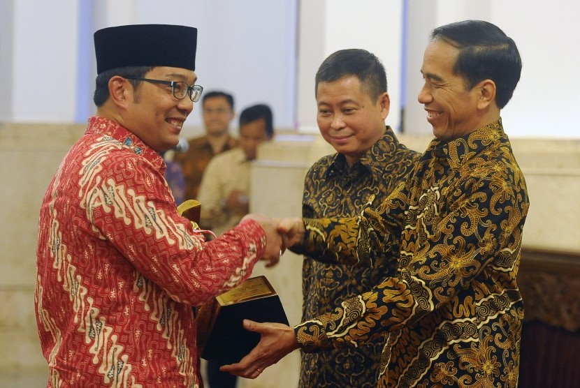 Presiden Joko Widodo (kanan) didampingi Menteri Perhubungan Ignasius Jonan (tengah) menyerahkan piala Wahana Tata Nugraha kepada Walikota Bandung Ridwan Kamil (kiri) di Istana Negara, Jakarta, Rabu (23/12). (Antara/Puspa Perwitasari)