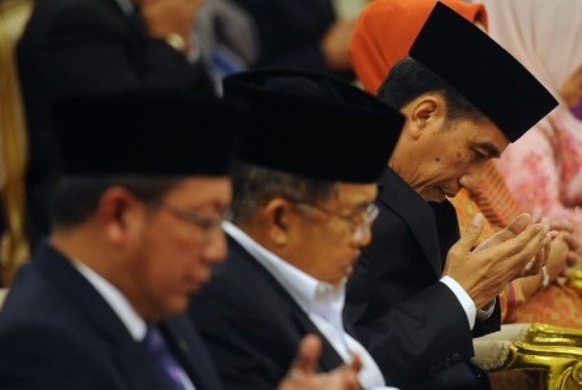 Presiden Joko Widodo (kanan) didampingi Wakil Presiden Jusuf Kalla (tengah) dan Menteri Agama Lukman Hakim Syaifuddin (kiri) memanjatkan doa dalam peringatan Maulid Nabi Muhammad SAW 1437 Hijriah di Istana Negara, Jakarta, Rabu (23/12).