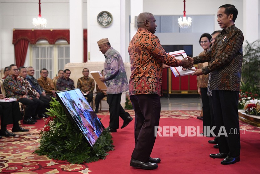 Presiden Joko Widodo (kanan) didampingi Wakil Presiden Jusuf Kalla (kedua kanan) dan Menkeu Sri Mulyani menyerahkan Daftar Isian Pelaksanaan Anggaran (DIPA) dan Daftar Alokasi Transfer Daerah dan serta Dana Desa kepada Gubernur Papua Barat Dominggus Mandacan di Istana Negara, Jakarta, Selasa (11/12/2018).