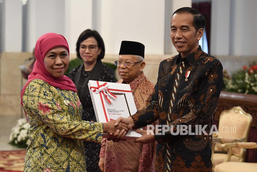 Presiden Joko Widodo (kanan) didampingi Wakil Presiden Maruf Amin (kedua kanan) dan Menteri Keuangan Sri Mulyani (kedua kiri) menyerahkan Daftar Isian Pelaksanaan Anggaran (DIPA) serta Buku Daftar Alokasi Transfer ke Daerah dan Dana Desa Tahun 2020 kepada Gubernur Jawa Timur Khofifah Indar Parawansa di Istana Negara, Jakarta, Kamis (14/11/2019).