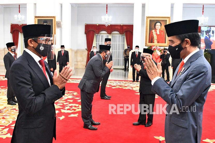 Presiden Joko Widodo (kanan) memberikan ucapan selamat kepada Menteri Pariwisata dan Ekonomi Kreatif Sandiaga Salahudin Uno (kiri) saat pelantikan menteri Kabinet Indonesia Maju, di Istana Negara Jakarta, Rabu (23/12).