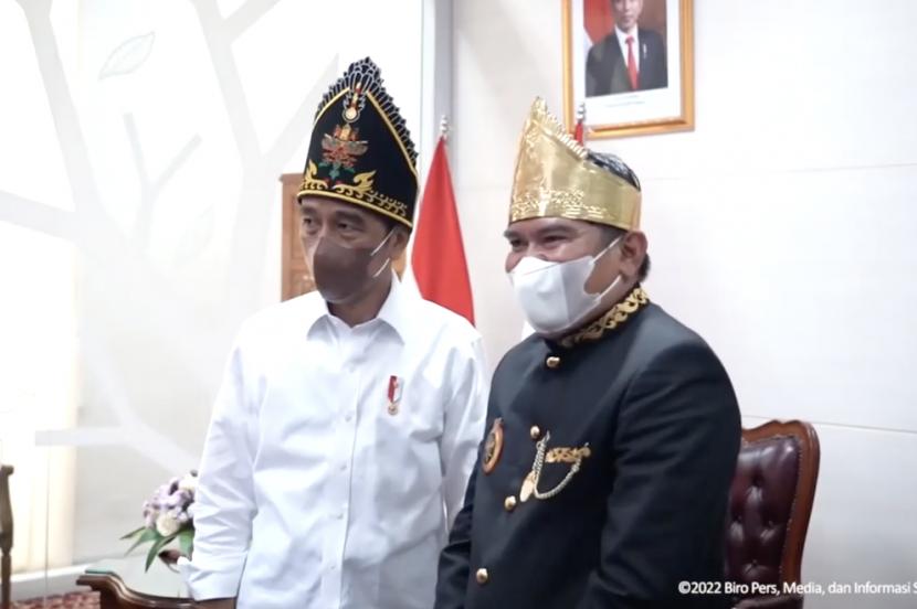 Presiden Joko Widodo (kiri) foto bersama dengan Sultan Paser Muhammad Jarnawi (kanan) saat kunjungan kerjanya ke Balikpapan, Kalimantan Timur, Senin (31/1/2022)) ..