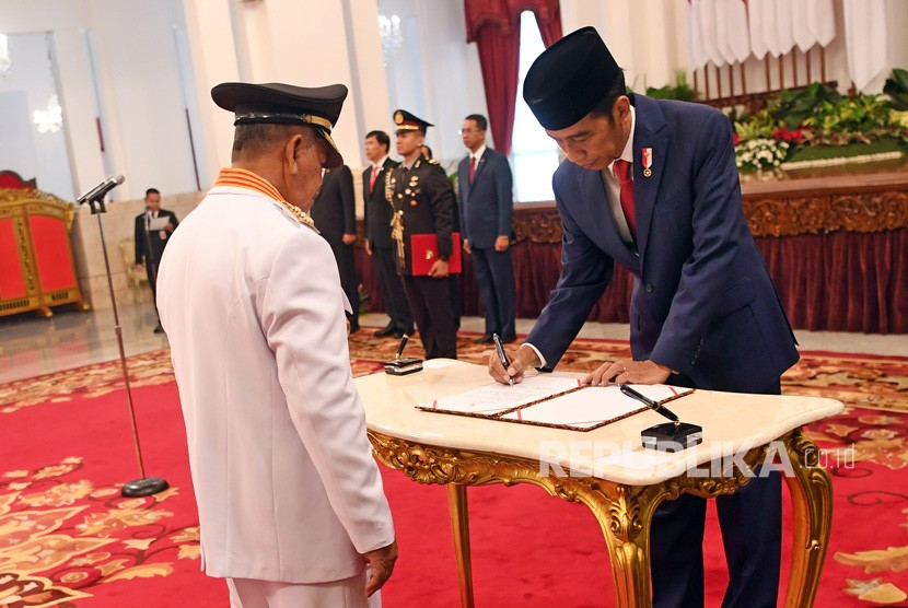 Presiden Joko Widodo (kanan) membubuhkan tanda tangan disaksikan Gubernur Maluku Utara Abdul Gani Kasuba (kiri) saat pelantikan di Istana Negara Jakarta, Jumat (10/5/2019).