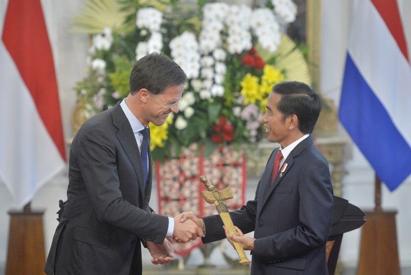 Presiden Joko Widodo (kanan) menerima artefak berupa keris dari Perdana Menteri Kerajaan Belanda Mark Rutte (kiri) saat kunjungan kerja di Istana Merdeka, Jakarta, Rabu (23/11). 