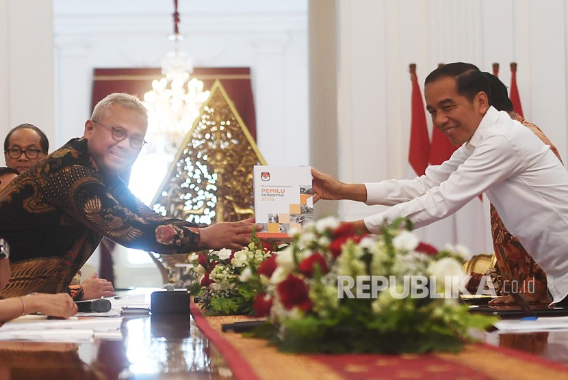 Presiden Joko Widodo (kanan) menerima buku laporan penyelenggaraan Pemilu Serentak tahun 2019 dari Ketua Komisi Pemilihan Umum (KPU) Arief Budiman dalam pertemuan di Istana Merdeka, Jakarta, Senin (11/11/2019). 