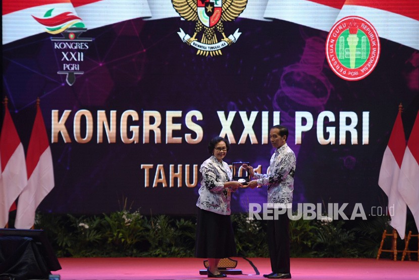 Presiden Joko Widodo (kanan) menerima penghargaan Maha Dwija Praja Nugraha atas kontribusinya dalam dunia pendidikan dari Ketua Umum Persatuan Guru Republik Indonesia (PGRI) Unifah Rosyidi saat menghadiri Kongres XXII PGRI tahun 2019 di Jakarta, Jumat (5/7/2019). 