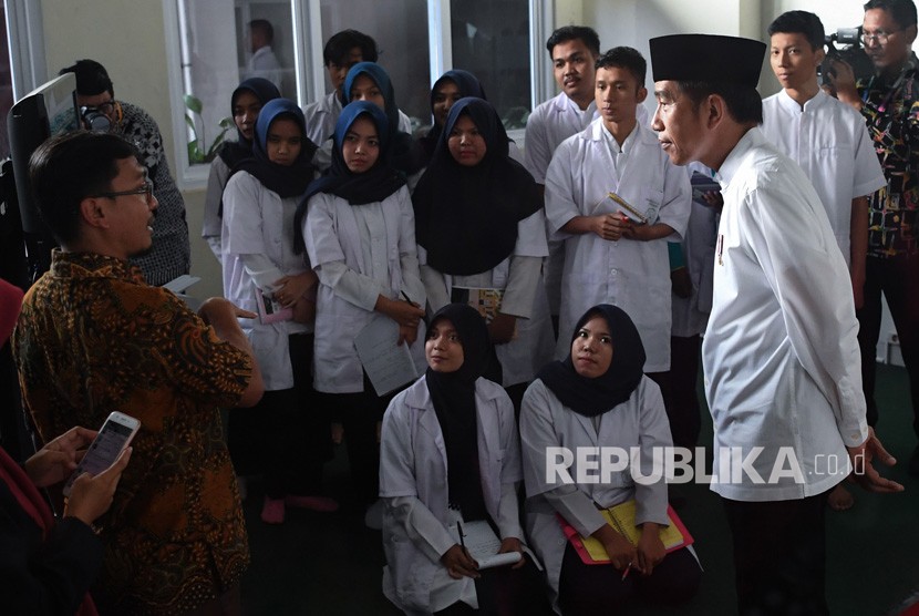 Presiden Joko Widodo (kanan) mengamati mahasiswa yang melakukan pelatihan ketika mengunjungi Universitas Aisyiyah di Yogyakarta, Kamis (6/12/2018).