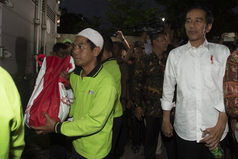 Presiden Joko Widodo (kanan) mengawasi pembagian sembako kepada warga di Gang Dahlia, Desa Cibuluh, Kabupaten Bogor, Jawa Barat, Kamis (8/7).