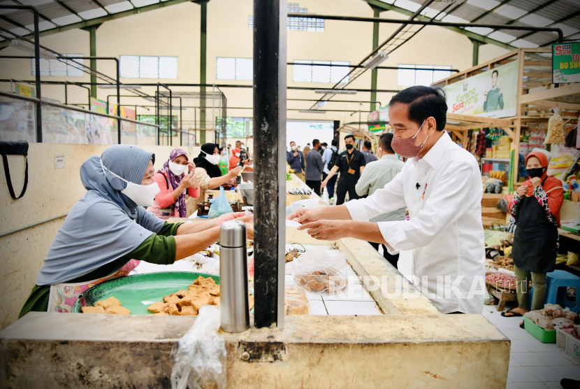 Presiden Joko Widodo (kanan) mengecek harga dan ketersediaan sejumlah bahan kebutuhan pokok masyarakat di Pasar Rakyat Desa Tempurejo, Kecamatan Tempuran, Kabupaten Magelang, Jawa Tengah, Rabu (30/3/2022). 