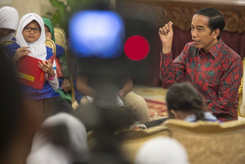 Presiden Joko Widodo (kanan) menjawab sejumlah pertanyaan dari perwakilan siswa sekolah dasar se-Jabodetabek yang berperan sebagai reporter cilik di Istana Negara, Jakarta, Selasa (20/10).