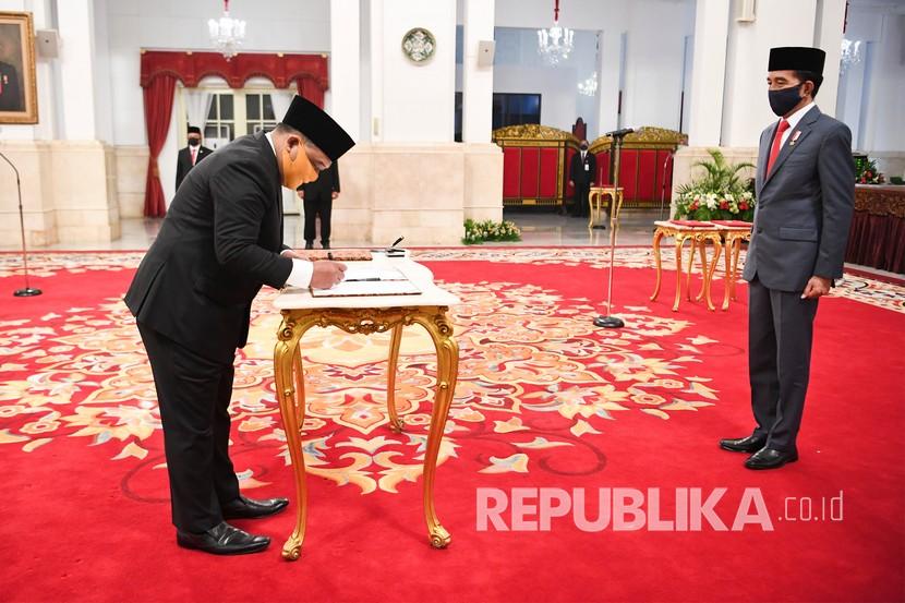 Presiden Joko Widodo (kanan) menyaksikan Kepala Badan Pelindungan Pekerja Migran Indonesia (BP2MI) Benny Rhamdani menandatangani berkas pelantikan di Istana Negara, Jakarta, Rabu (15/4/2020). Presiden Joko Widodo resmi melantik Benny Rhamdani menjadi Kepala BP2MI. 