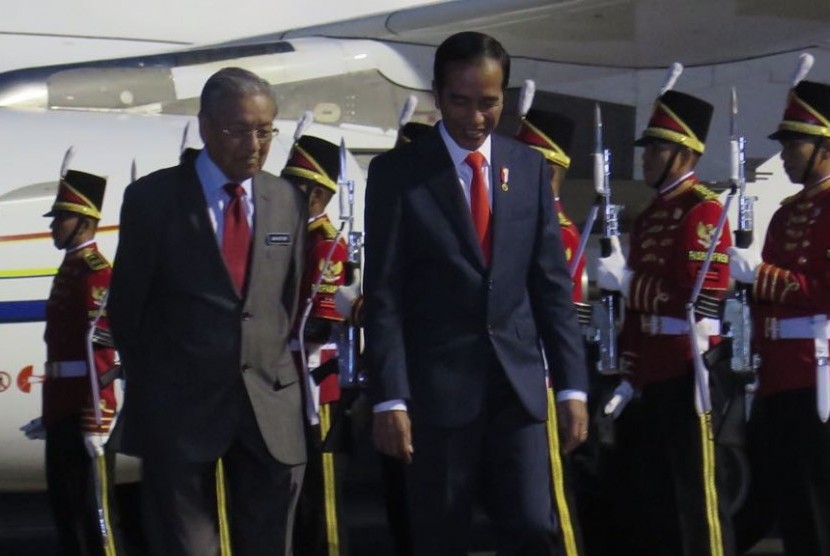 Presiden Joko Widodo (kanan) menyambut kedatangan Perdana Menteri Malaysia Mahathir Mohamad di bandara Halim Perdanakusuma, Jakarta, Kamis (28/6).