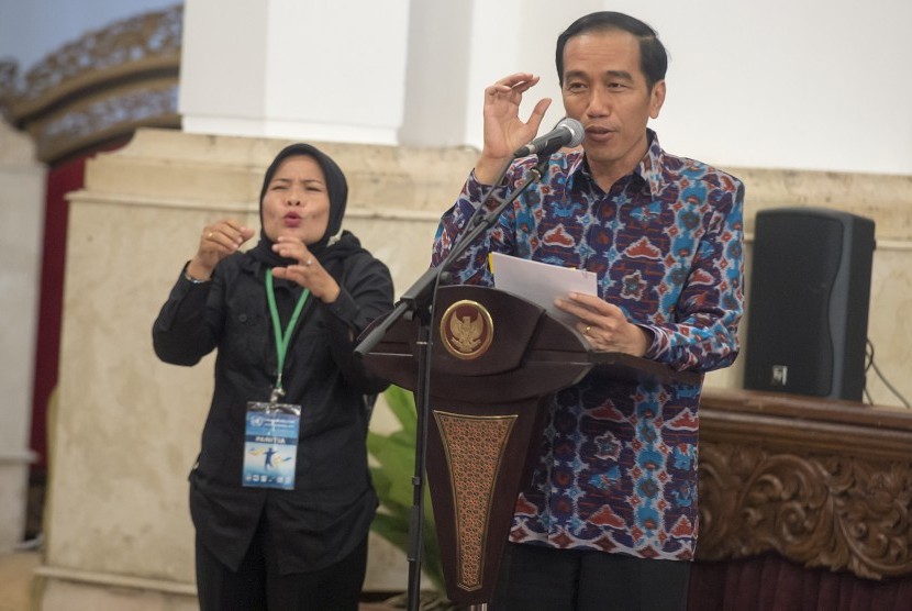 Presiden Joko Widodo (kanan) menyampaikan sambutannya dengan diterjemahkan ke dalam bahasa isyarat oleh petugas (kiri) pada acara puncak peringatan Hari Disabilitas Internasional Tahun 2015 di Istana Negara, Jakarta, Kamis (3/12).