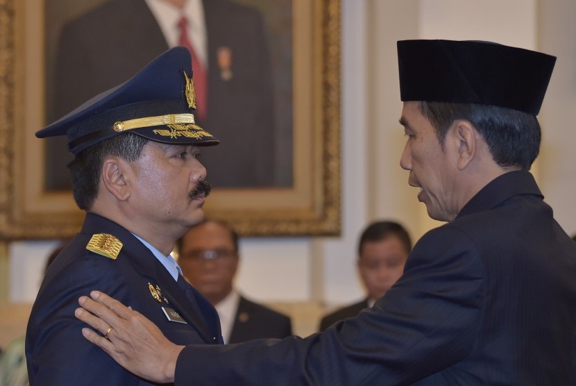 Presiden Joko Widodo (kanan) menyematkan tanda jabatan kepada Marsekal Madya (Marsdya) Hadi Tjahjanto saat pelantikan Kepala Staf TNI Angkatan Udara (KSAU) di Istana Negara, Jakarta, Rabu (18/1).