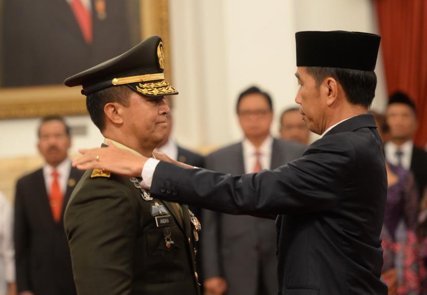 Presiden Joko Widodo (kanan) menyematkan tanda kenaikan pangkat Henderal kepada KSAD Andika Perkasa saat upacara pelantikan di Istana Negara.