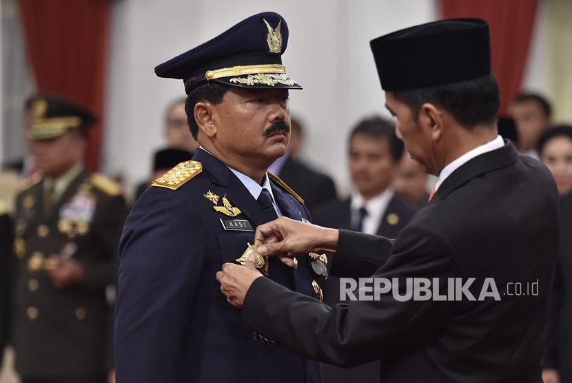 Presiden Joko Widodo (kanan) menyematkan tanda pangkat kepada Panglima TNI Marsekal TNI Hadi Tjahjanto (kedua kiri) saat upacara pelantikan di Istana Negara, Jakarta, Jumat (8/12).