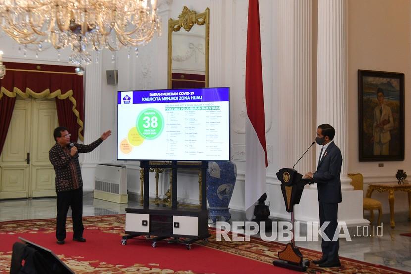Presiden Joko Widodo (kanan) menyimak penjelasan Ketua Tim Pakar Gugus Tugas Nasional Percepatan Penanganan Covid-19 Wiku Adisasmito di Istana Merdeka, Jakarta. (ilustrasi)