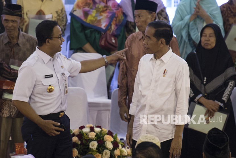 Presiden Joko Widodo (kedua kanan) berbincang dengan Gubernur DKI Jakarta Anies Baswedan (kiri) usai menyerahkan Sertifikat Tanah untuk Rakyat di Cengkareng, Jakarta, Rabu (9/1/2019). 