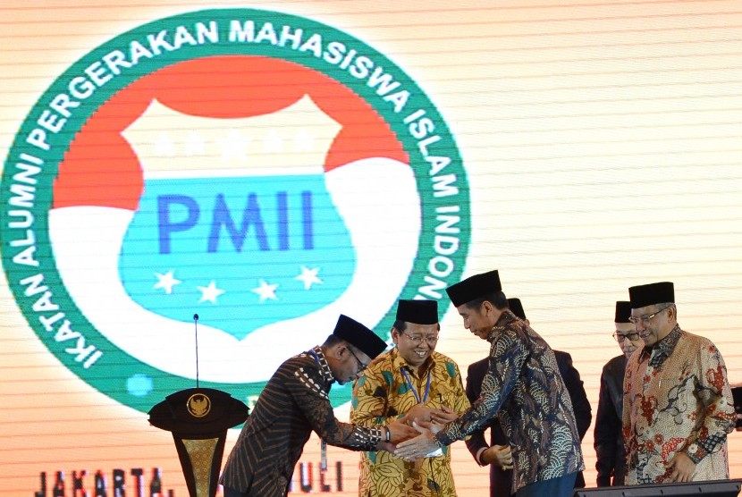 Presiden Joko Widodo (kedua kanan) berjabat tangan dengan Sekjen Ikatan Alumni Pergerakan Mahasiswa Islam Indonesia (PMII) Hanif Dhakiri (kiri) disaksikan Ketua Umum PBNU Said Aqil Siroj (kanan) dan Ketua Umum Ikatan Alumni PMII Ahmad Muqowam seusai membuka munas ke-VI Ikatan Alumni PMII di Jakarta, Jumat (20/7). 