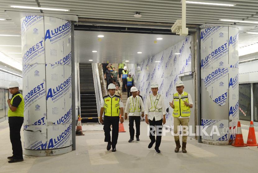 Presiden Joko Widodo (kedua kanan) bersama Menteri Perhubungan Budi Karya Sumadi (kedua kiri), Gubernur DKI Jakarta Anies Baswedan (kiri) dan Direktur Utama PT MRT Jakarta William Sabandar (kanan) saat tiba untuk meninjau kereta MRT di Stasiun Bundaran HI, Jakarta, Selasa (6/11).