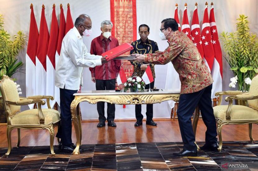Presiden Joko Widodo (kedua kanan) dan Perdana Menteri Singapura Lee Hsien Loong (kedua kiri) menyaksikan Menteri Hukum dan HAM Yasonna Laoly (kanan) dan Menteri Dalam Negeri Singapura K Shanmugam bertukar dokumen perjanjian ekstradisi di The Sanchaya Resort Bintan, Kabupaten Bintan, Kepulauan Riau, Selasa (25/1/2022). 