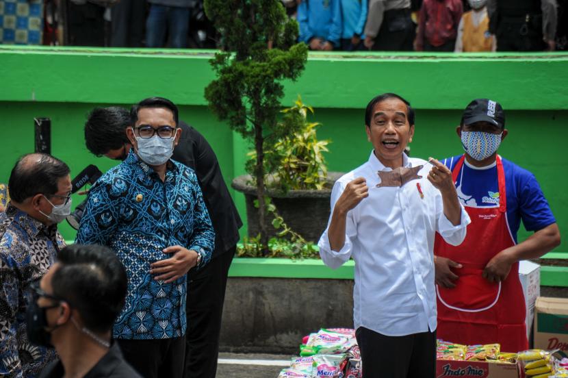 Presiden Joko Widodo (kedua kanan) didampingi Gubernur Jawa Barat Ridwan Kamil (kedua kiri) menyapa warga di Pasar Sederhana, Bandung, Jawa Barat, Senin (17/1/2022).