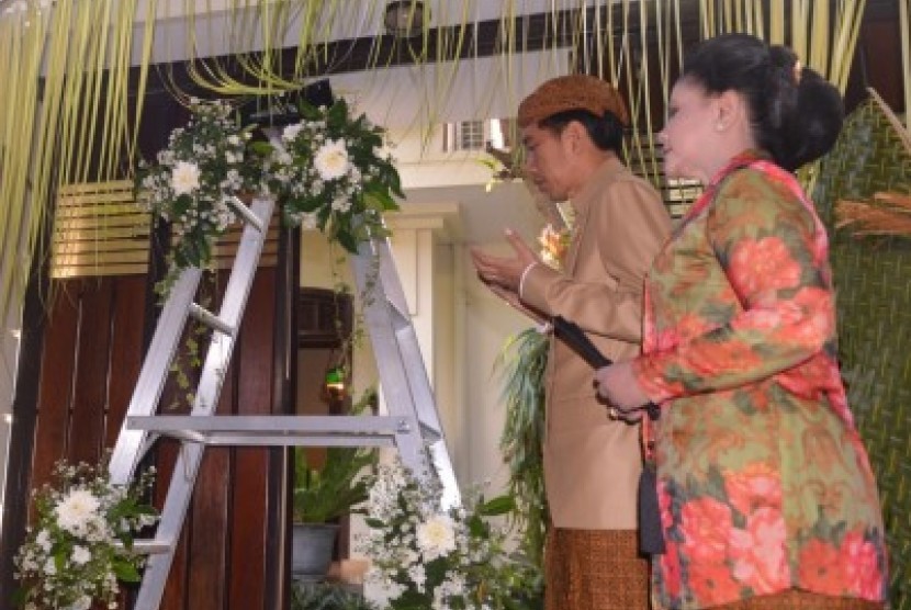 Presiden Joko Widodo (kedua kanan) didampingi Ibu Negara Iriana Joko Widodo (kanan) bersiap memasang 