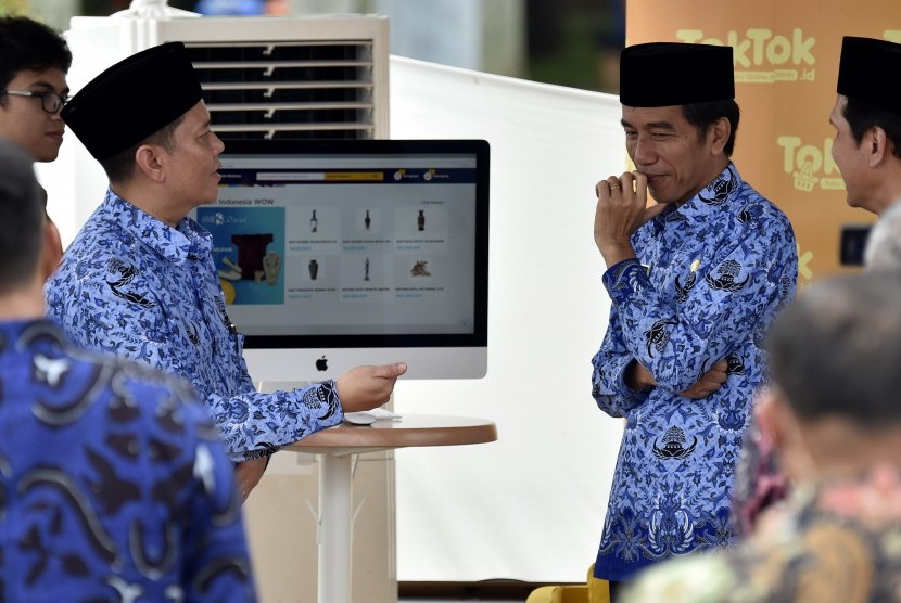 Presiden Joko Widodo (kedua kanan) didampingi Ketua Umum Dewan Pimpinan Nasional Korpri, Zudan Arif Fakhrulloh (kedua kiri) meninjau stan toko online KORPRI disela-sela peringatan HUT ke-45 KORPRI di Monumen Nasional, Jakarta, Selasa (29/11). 