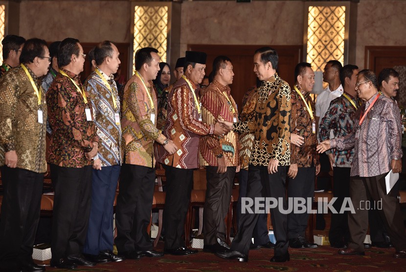 Presiden Joko Widodo (kedua kanan) didampingi Menko Perekonomian Darmin Nasution (kanan) menyapa kepala daerah yang hadir dalam Pembukaan Rapat Koordinasi Nasional Pengendalian Inflasi Tahun 2018 di Jakarta, Kamis (26/7). 
