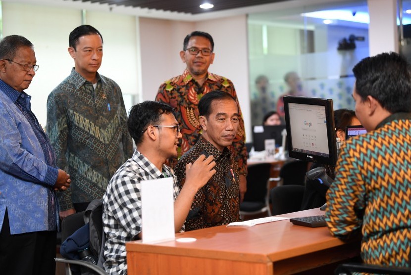 Presiden Joko Widodo (kedua kanan) didampingi Menko Perekonomian Darmin Nasution (kiri) dan Kepala BKPM Thomas Lembong (kedua kiri) berbincang dengan masyarakat ketika meninjau layanan konsultasi Online Single Submission (OSS) BKPM di PTSP BKPM Jakarta, Senin (14/1/2019).