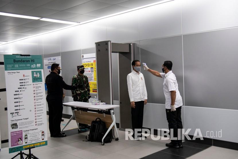 Presiden Joko Widodo (kedua kanan) didampingi Panglima TNI Hadi Tjahjanto (kedua kiri) diperiksa suhunya saat meninjau kesiapan penerapan prosedur standar new normal di Stasiun MRT Bundaraan HI, Jakarta, Selasa (26/5). 