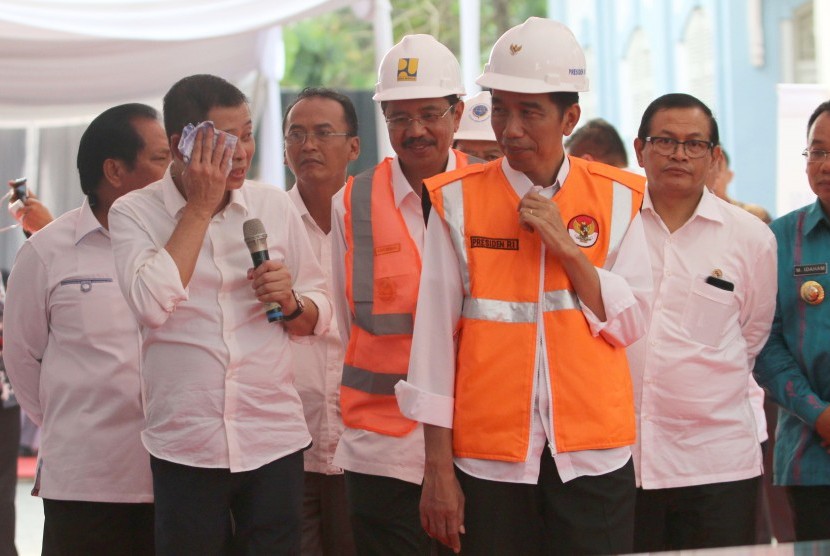 Presiden Joko Widodo (kedua kanan) didampingi Seskab PramMenhub Ignasius Jonan (kedua kiri) memberikan penjelasan kepada Presiden Jokowi saat meninjau pembangunan reaktivasi jalur kereta api Trans Sumatra.