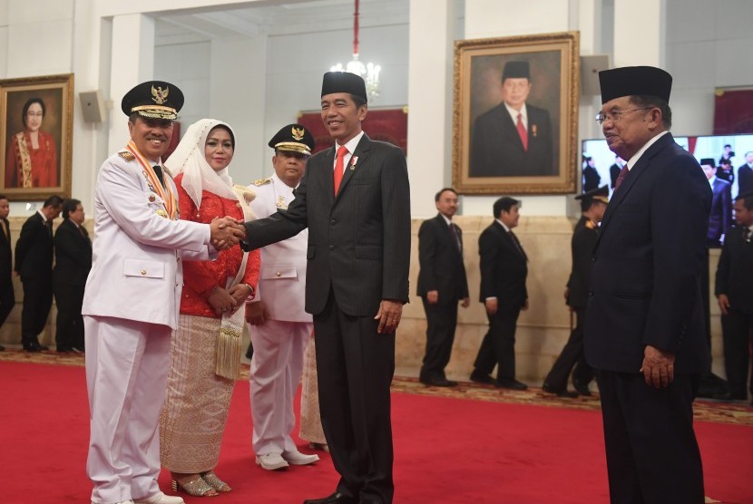 Presiden Joko Widodo (kedua kanan) didampingi Wakil Presiden Jusuf Kalla (kanan) berjabat tangan dengan Gubernur Riau yang baru dilantik Syamsuar (kiri) dan Wakil Gubernur Riau Edi Natar Nasution (ketiga kiri) di Istana Negara, Jakarta (20/2).