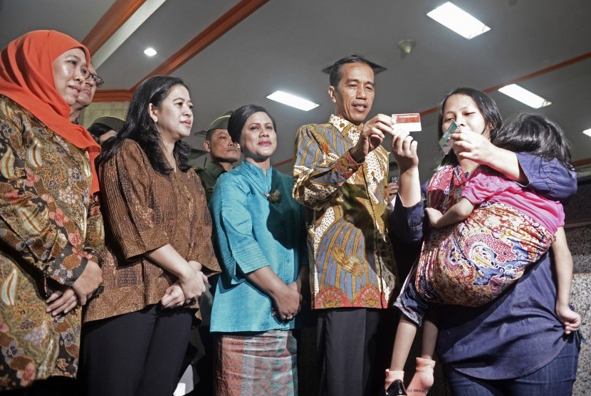 Presiden Joko Widodo (kedua kanan) memberi Kartu Indonesia Sehat (KIS), Kartu Indonesia Pintar (KIP) dan Kartu Keluarga Sejahtera (KKS) secara simbolis pada warga yang berhak.
