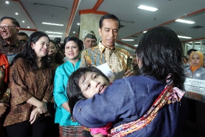 Presiden Joko Widodo (kedua kanan) memberi Kartu Indonesia Sehat (KIS), Kartu Indonesia Pintar (KIP) dan Kartu Keluarga Sejahtera (KKS).