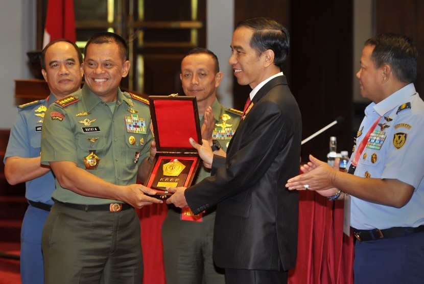 Presiden Joko Widodo (kedua kanan) menerima cendera mata dari Panglima TNI Jenderal TNI Gatot Nurmantyo (kedua kiri), usai pembukaan Rapat Pimpinan TNI di Mabes TNI Cilangkap, Jakarta, Rabu (15/12). (Antara/Yudhi Mahatma)