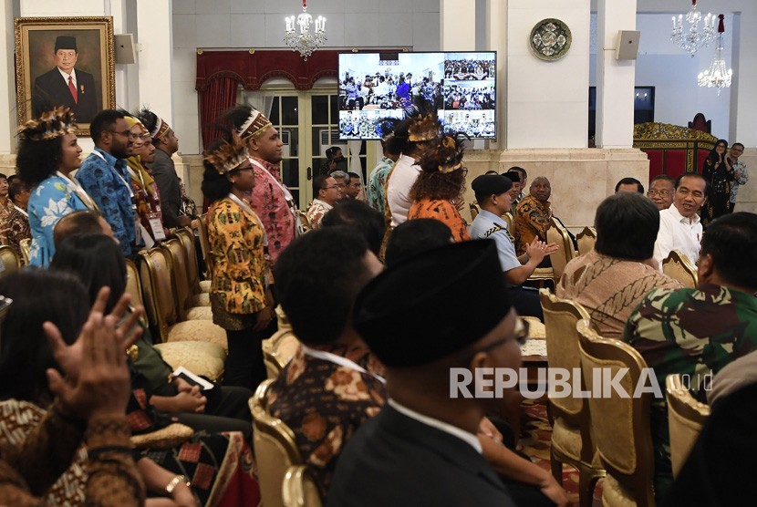 Presiden Joko Widodo (kedua kanan) menyapa perwakilan masyarakat Papua di sela-sela peresmian pengoperasian Palapa Ring di Istana Negara, Jakarta, Senin (14/10/2019).