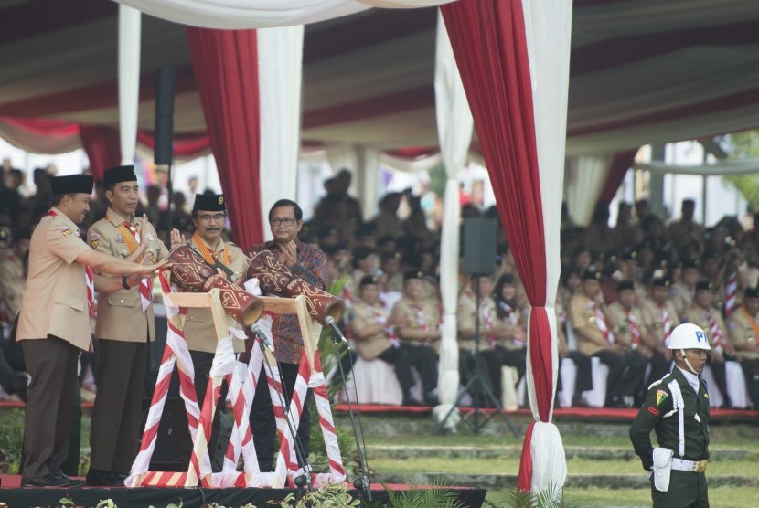 Presiden Joko Widodo (kedua kiri) bersama Menpora Imam Nahrawi (kiri), Seskab Pramono Anung (kanan), dan Ketua Kwartir Nasional Gerakan Pramuka Adhyaksa Dault (kedua kanan) memukul tifa sebagai tanda dibukanya Raimuna Nasional XI yang bertepatan dengan peringatan ulang tahun Pramuka ke-56 di, Bumi Perkemahan Cibubur, Jakarta, Senin (14/8).