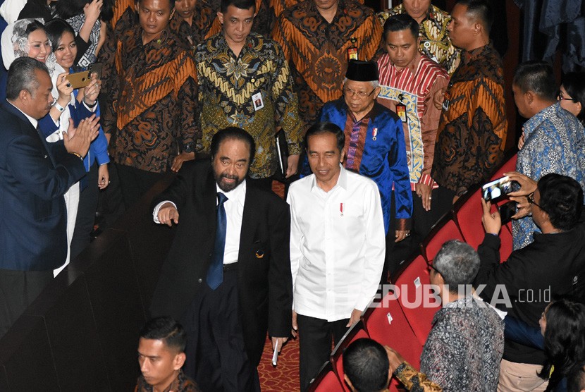 Presiden Joko Widodo (kedua kiri) dan Wakil Presiden Maruf Amin (tengah) berjalan bersama Ketua Umum Partai Nasdem Surya Paloh (kiri) saat menghadiri penutupan Kongres II Partai Nasdem dan HUT ke-8 Partai Nasdem di Jakarta International Teathre, Jakarta, Senin (11/11/2019). 