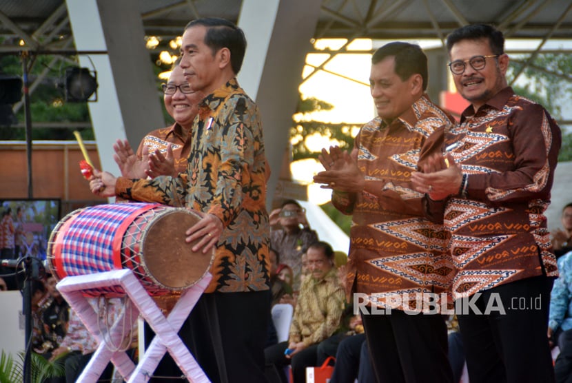 Presiden Joko Widodo (kedua kiri) di dampingi Menteri Koperasi dan UMKM, AA Gede Ngurah Puspayoga (kiri), Ketua Dewan Koperasi Indonesia, Nurdin Halid (kedua kanan), dan Gubernur Sulsel Syahrul Yasin Limpo (kanan) memukul gendang saat peringatan Hari Koperasi Nasional (Harkopnas) ke-70 di Lapangan Karebosi, Makassar, Sulawesi Selatan, Rabu (12/7).