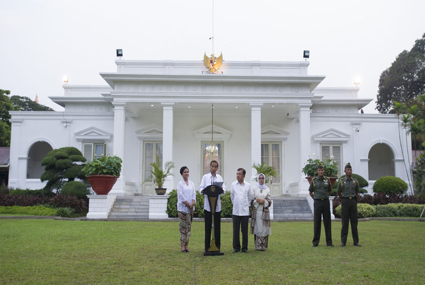  Presiden Joko Widodo (kedua kiri) didampingi Ibu Iriana Joko Widodo (kiri), Wapres Jusuf Kalla (keempat kanan), dan Ibu Mufidah Jusuf Kalla (ketiga kanan) mengumumkan susunan menteri Kabinet Kerja di Istana Merdeka, Jakarta, Ahad (26/10). 