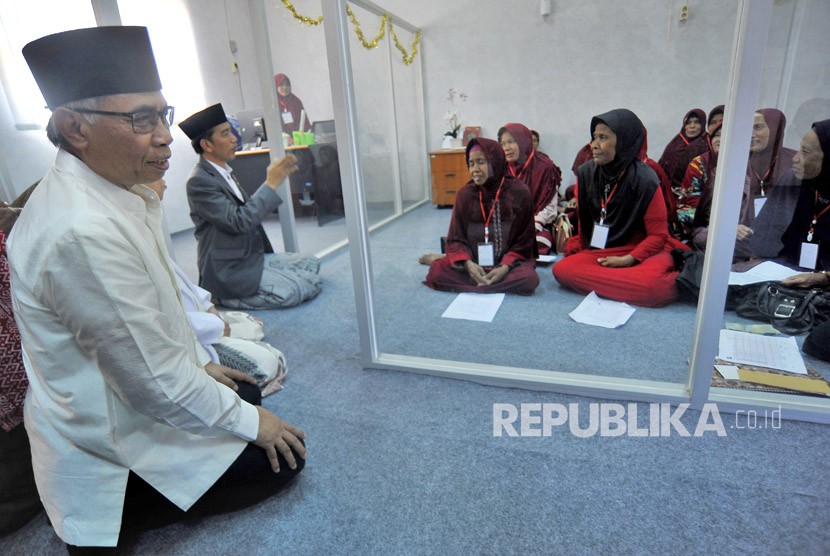 Presiden Joko Widodo (kedua kiri) didampingi Ketua Dewan Komisioner OJK (Otoritas Jasa Keuangan) Wimboh Santoso (kiri) berdialog dengan nasabah Bank Wakaf Mikro Tanara saat Peluncuran Bank Wakaf Mikro Tanara di Serang, Banten, Rabu (14/3).