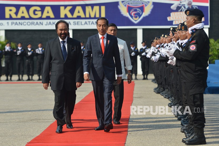 President Joko Widodo (second left) accompanied by Nasdem Party Chairman Surya Paloh (left) and Coordinating Minister for Political, Legal, and Security Affairs Wiranto (third left) inspect participants of Nasdem's State Defense Academy Batch II in Jakarta, Monday (July 16).