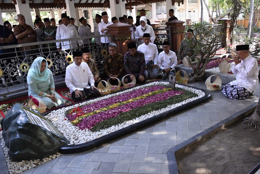 Presiden Joko Widodo (kedua kiri) didampingi Pengasuh Pondok Pesantren Tebuireng Salahuddin Wahid (kanan), putri almarhum KH Abdurrahman Wahid, Yenny Wahid (kiri), dan Gubernur Jawa Timur Soekarwo (ketiga kiri) menziarahi makam KH Abdurahman Wahid atau Gus Dur di Jombang, Jawa Timur, Selasa (18/12/2018).