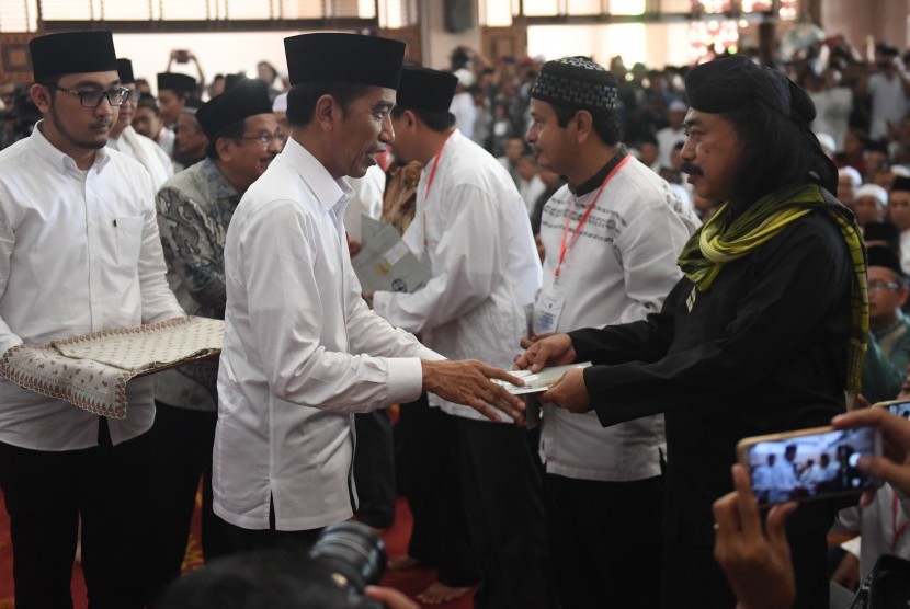 Jokowi Bagi Sertifikat Wakaf: Presiden Joko Widodo (kedua kiri) memberikan sertifikat tanah wakaf kepada warga di Masjid Raya Bani Umar, Tangerang Selatan, Jumat (22/2/2019).