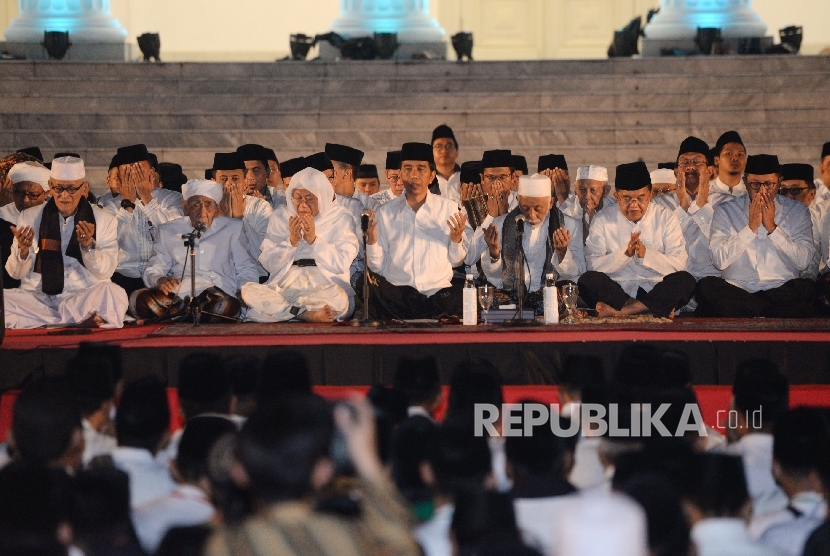 Presiden Joko Widodo (keempat kanan), Wapres Jusuf Kalla (kedua kanan), Pimpinan Pondok Pesantren Al-Anwar KH Maimun Zubair, Ketua Umum MUI Maruf Amin, Tokoh Ulama Banten Abuya Muhtadi, dan Menteri Agama Lukman Hakim Saifuddin (dari kedua kiri) mengikuti Dzikir Kebangsaan di Halaman Istana Merdeka, Jakarta, Selasa (1/8) malam.