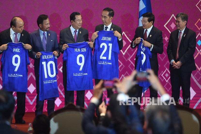 Presiden Joko Widodo (ketiga kanan) bersama kepala negara dan kepala pemerintahan negara-negara ASEAN menunjukkan kaos sepak bola (jersey) bertuliskan namanya masing-masing disaksikan Sekjen ASEAN Dato Lim Jock Hoi (kanan) usai menyaksikan penandatanganan Nota Kesepahaman antara FIFA dan ASEAN di Bangkok, Thailand, Sabtu (2/11/2019). 
