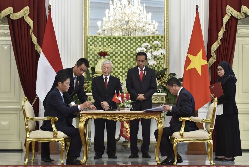 Presiden Joko Widodo (ketiga kanan) dan Sekretaris Jenderal Partai Komunis Vietnam Nguyen Phu Trong (ketiga kiri) menyaksikan penandatanganan kerjasama antaran Menteri ESDM Ignasius Jonan (kanan) dan Menteri Industri dan Perdagangan Vietnam Tran Tuan Anh (kiri) di Istana Merdeka, Jakarta, Rabu (23/8). 