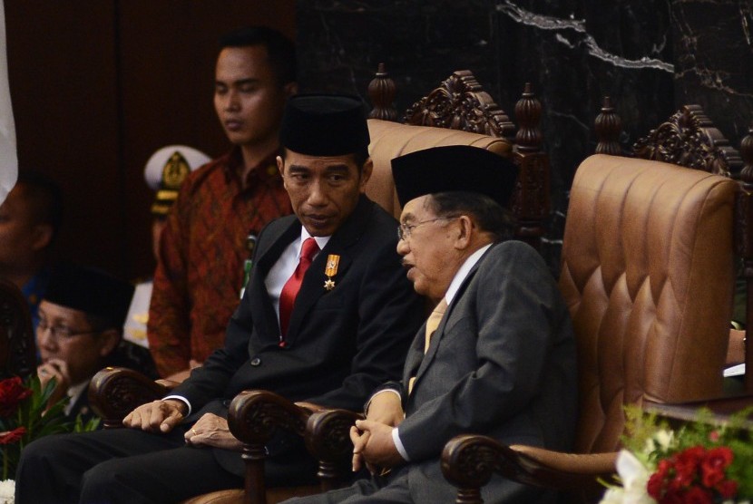 Presiden Joko Widodo (kiri) berbincang bersama Wakil Presiden Jusuf Kalla (kanan) sesaat sebelum pembacaan pidato tanggapan penyampaian nota keuangan dan RAPBN 2016 oleh di Kompleks Parlemen, Jakarta, Jumat (14/8). 
